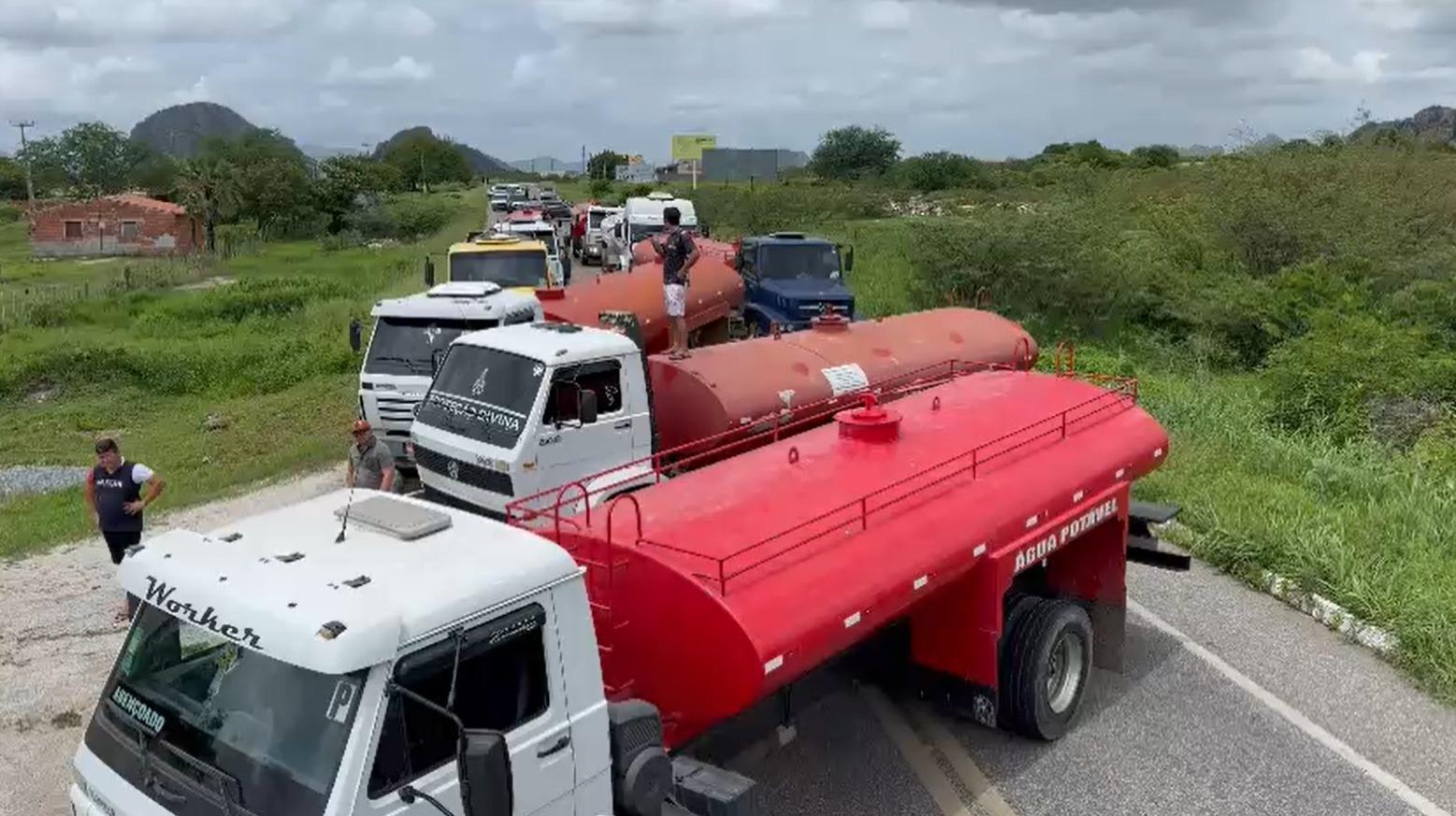 Foto de carros-pipa bloqueando trecho de rodovia BR-122 no Ceará em protesto por falta de pagamento aos pipeiros