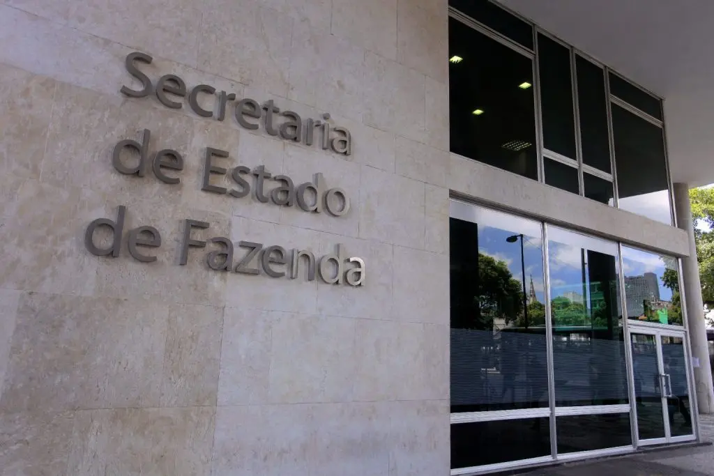 Fachada da Secretaria de Estado de Fazenda, destacando sua arquitetura moderna e o logotipo em destaque, representando eficiência e transparência no serviço público.