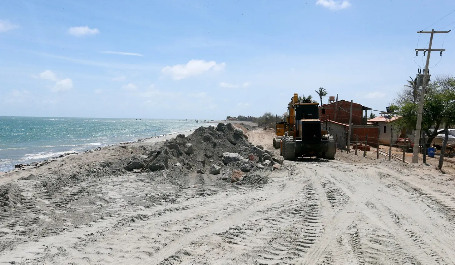Trator move areia para formar muro na praia de Icapuí