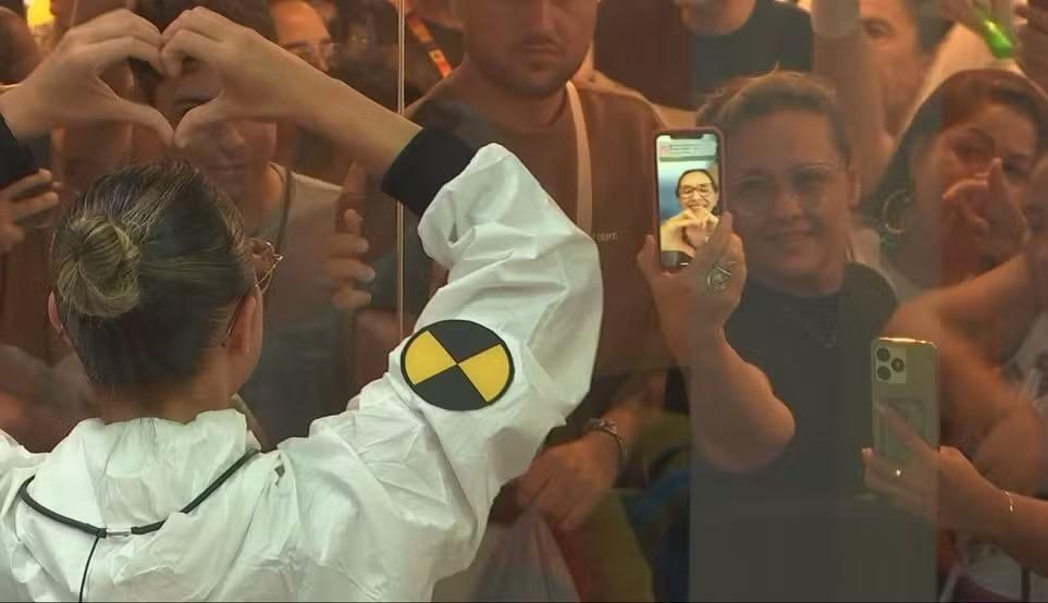 Renata faz coração com as mãos para a mãe por videochamada