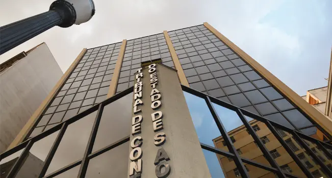 Imagem do Tribunal de Contas do Estado de São Paulo, destacando sua arquitetura moderna e fachada imponente em um dia nublado.