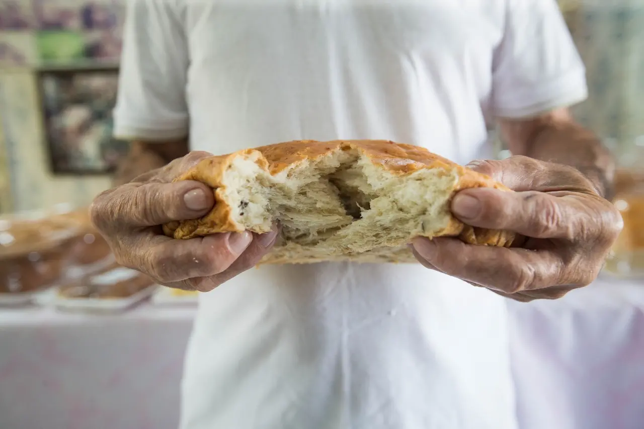 mão partindo o pão