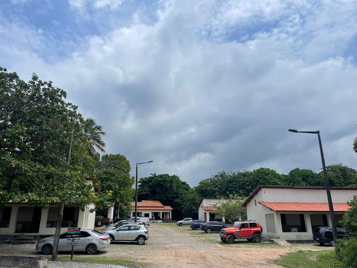 Céu nublado no Sesc Iparana, com chalés e carros estacionados