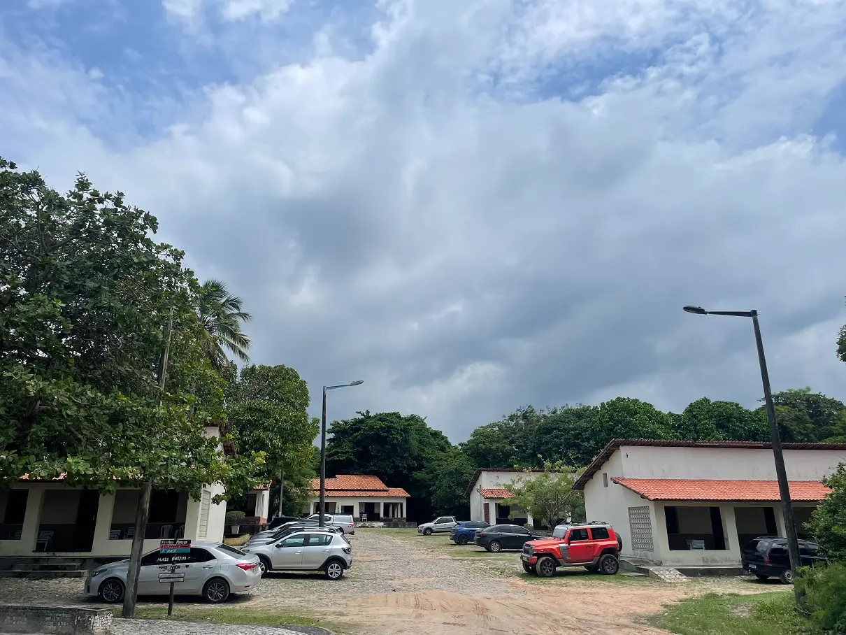 Céu nublado no Sesc Iparana, com chalés e carros estacionados