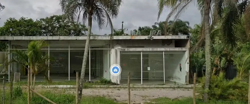 Um prédio abandonado e sujo com um matagal ao redor. Não existem móveis no interior do local para matéria sobre loja de luxo investigada por denúncias no Procon