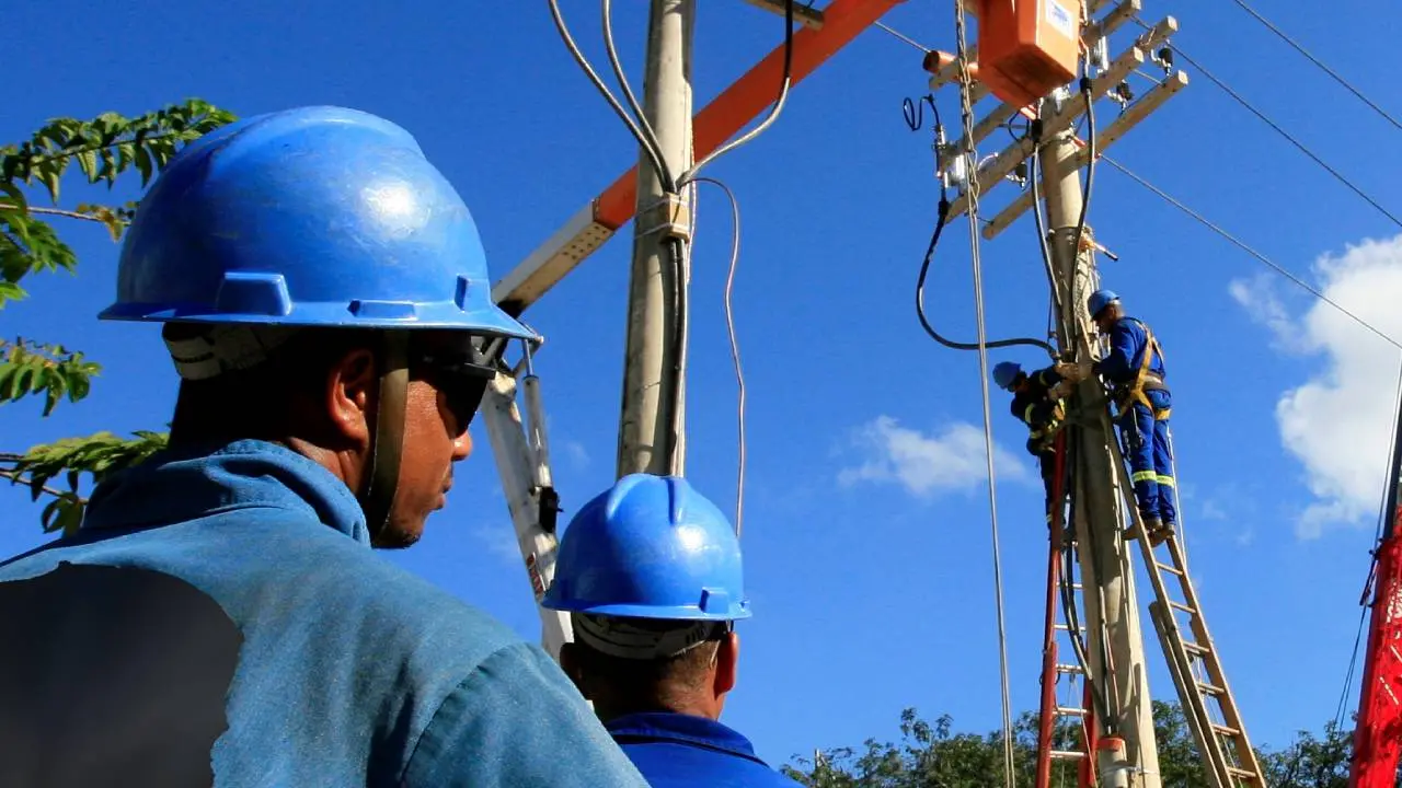 Eletricistas trabalhando em poste