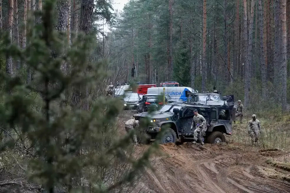 A imagem mostram soldados em terreno pantanoso com carros militares em meio a uma densa floresta em busca de soldados americanos desaparecidos na Lituânia