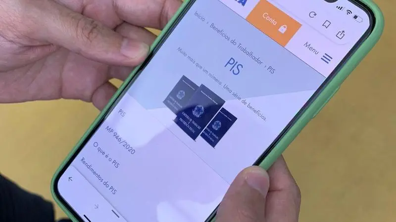 Mão segura o celular com aplicativo do PIS