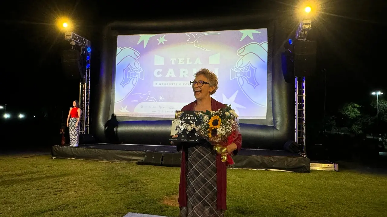 Marcélia Cartaxo com buquê de flores no palco