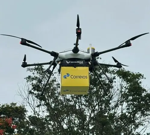A imagem mostra um drone levando uma encomenda