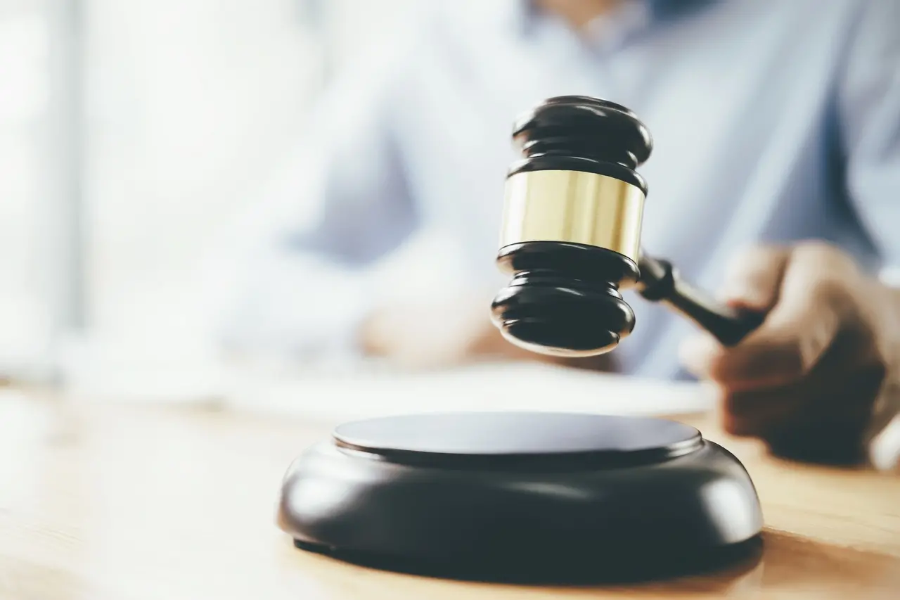 Um juiz batendo o martelo em um tribunal, simbolizando a decisão e a justiça. O martelo é um símbolo do sistema judiciário e da lei.