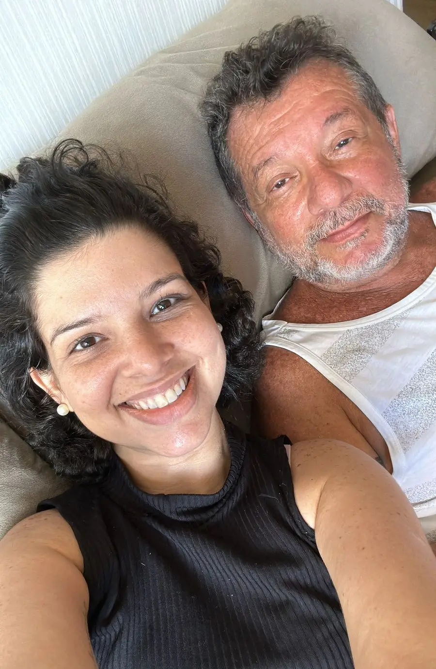 Mariana deitada no sofá ao lado do pai