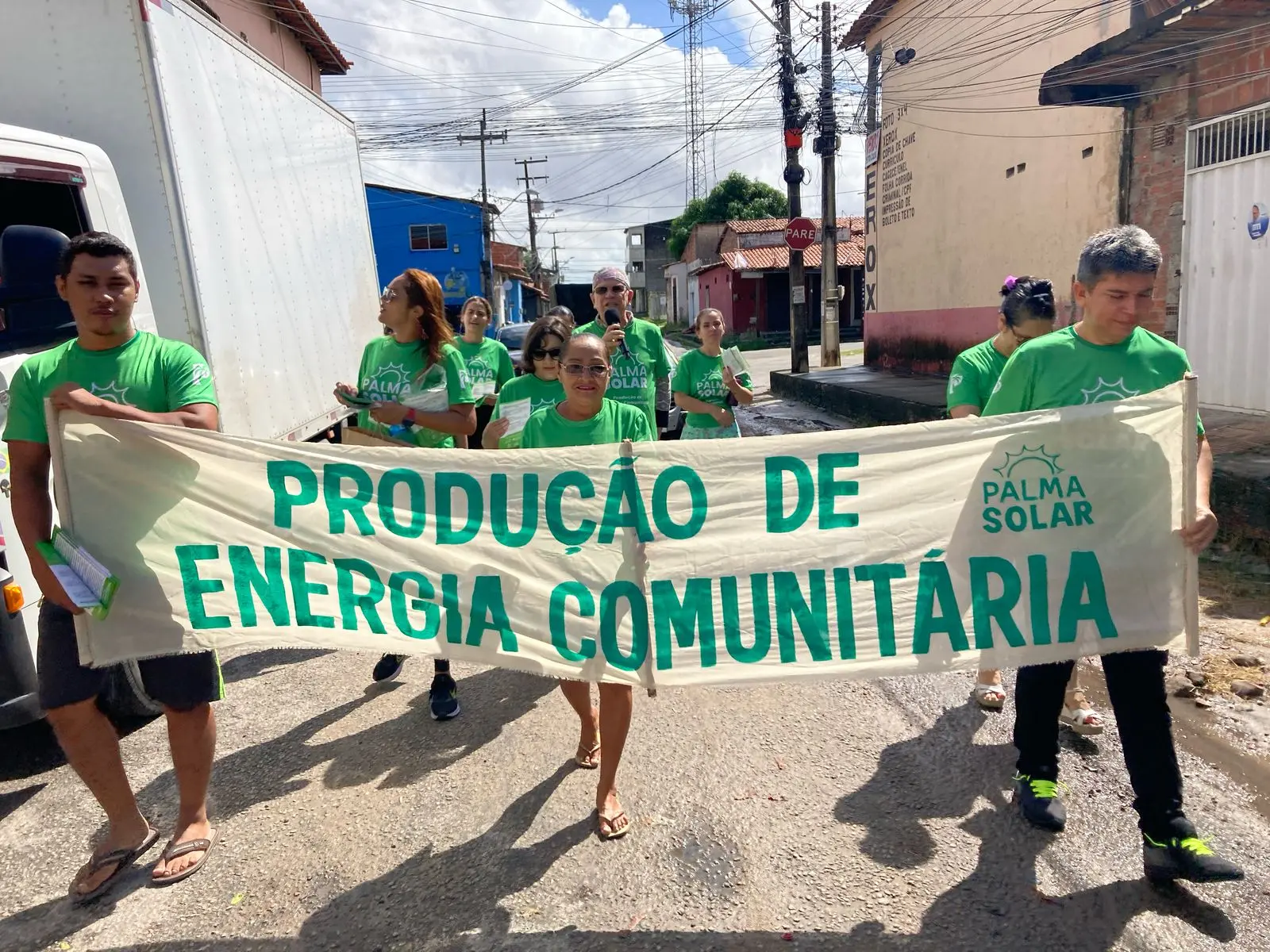 Pessoas andando com faixa defendendo a energia comunitária
