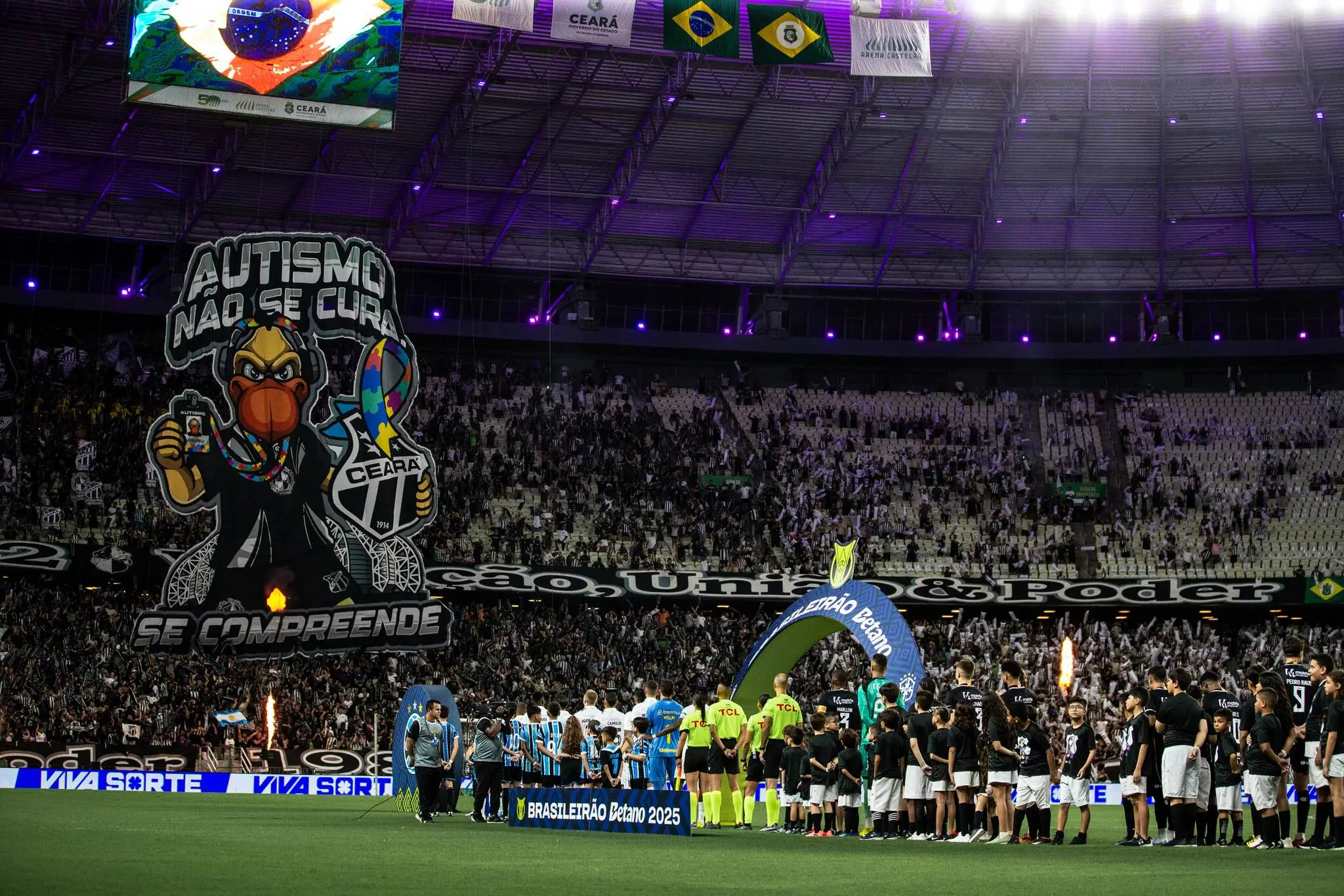 Foto da entrada de campo com o mosaico do autismo