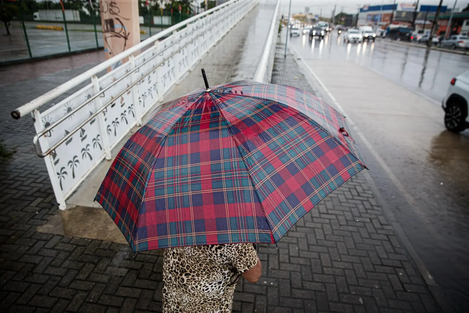 Mulher com guarda chuva em Fortaleza, cidade com previsão de chuvas e ventos intensos