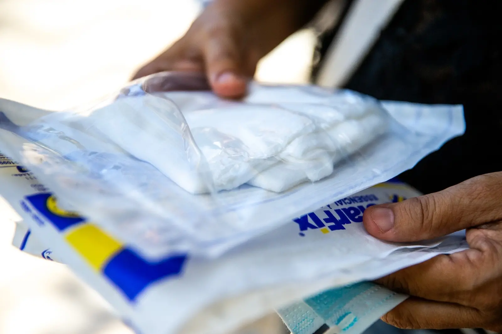 Mulher com pacotes de gaze na mão, durante falta de medicamentos e insumos no IJF