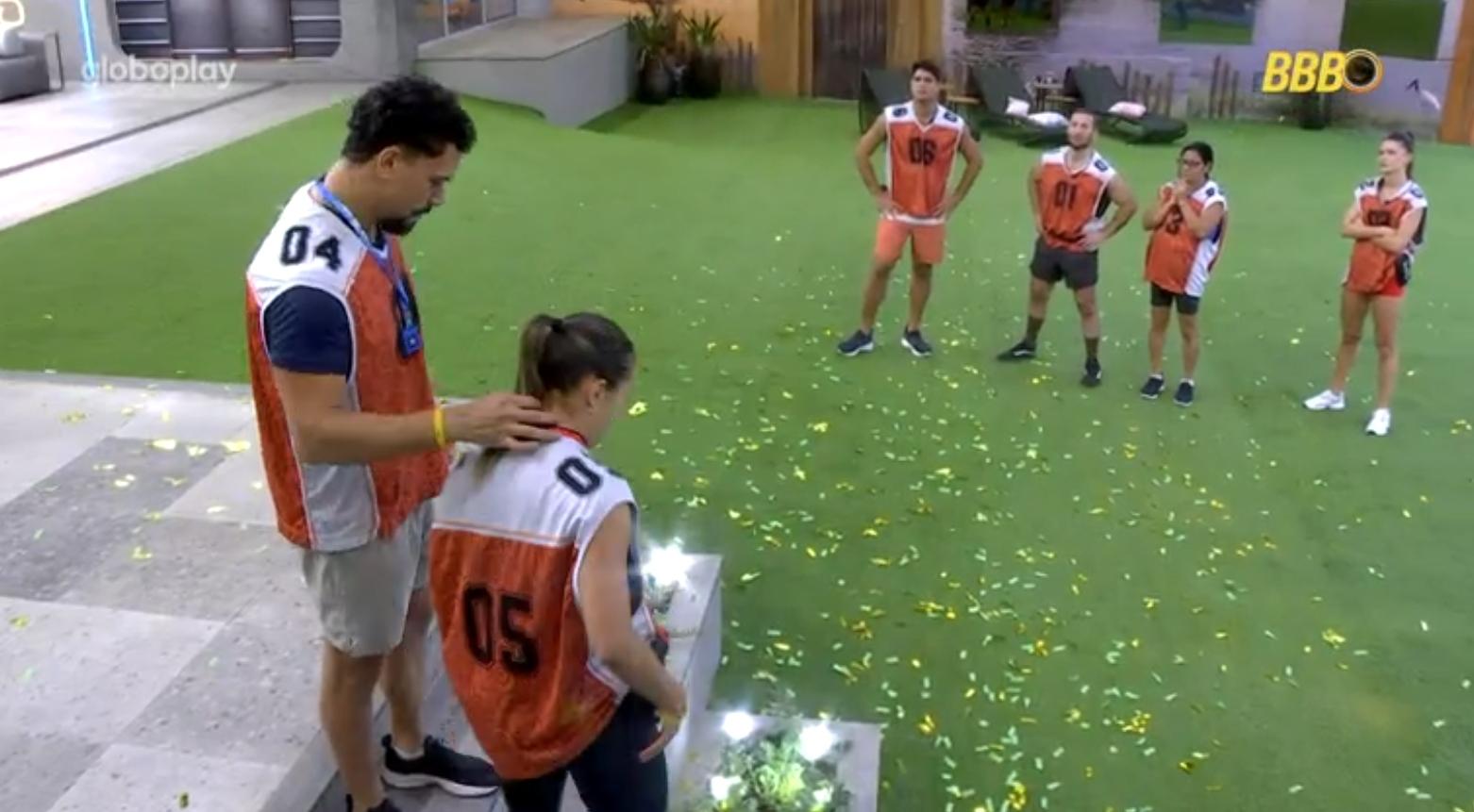 Imagem mostra Vinícius dando o Monstro para Renata na Prova do Anjo