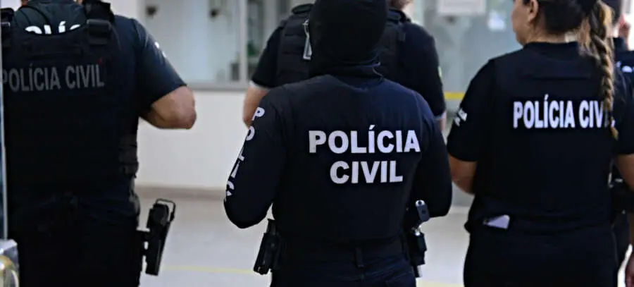Na imagem vemos agentes da Polícia Civil de costas