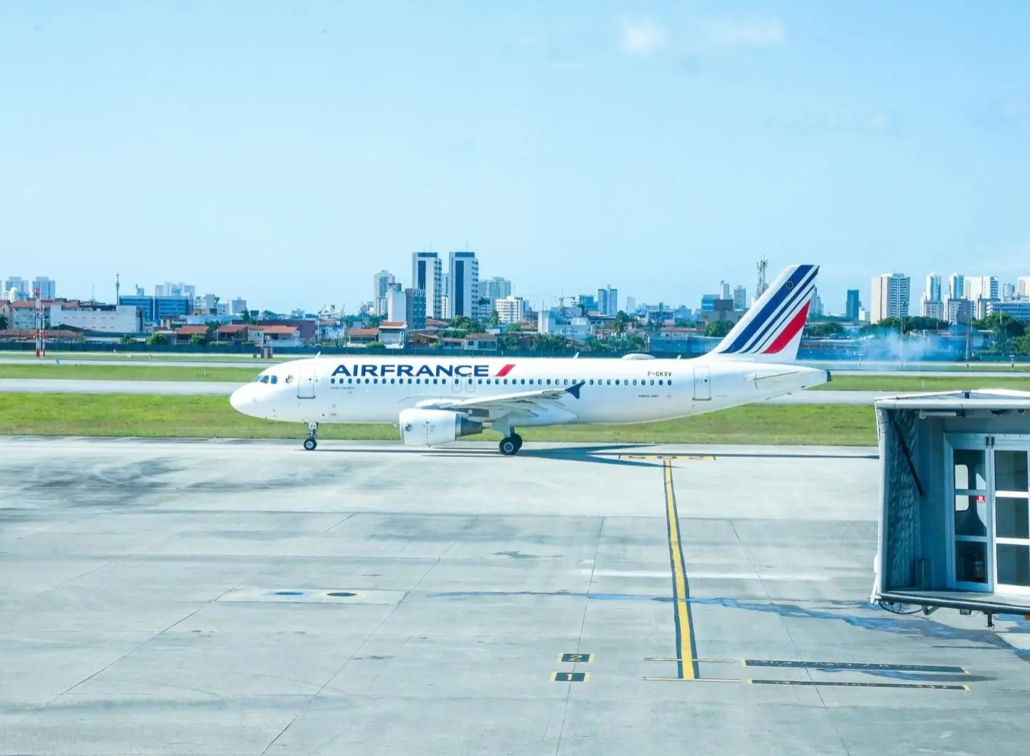 Foto que contém uma aeronave da Air France no Aeroporto Internacional de Fortaleza. Aeronave é branca com detalhes em vermelho e azul e está percorrendo taxiway em direção à cabeceira 13 da pista.