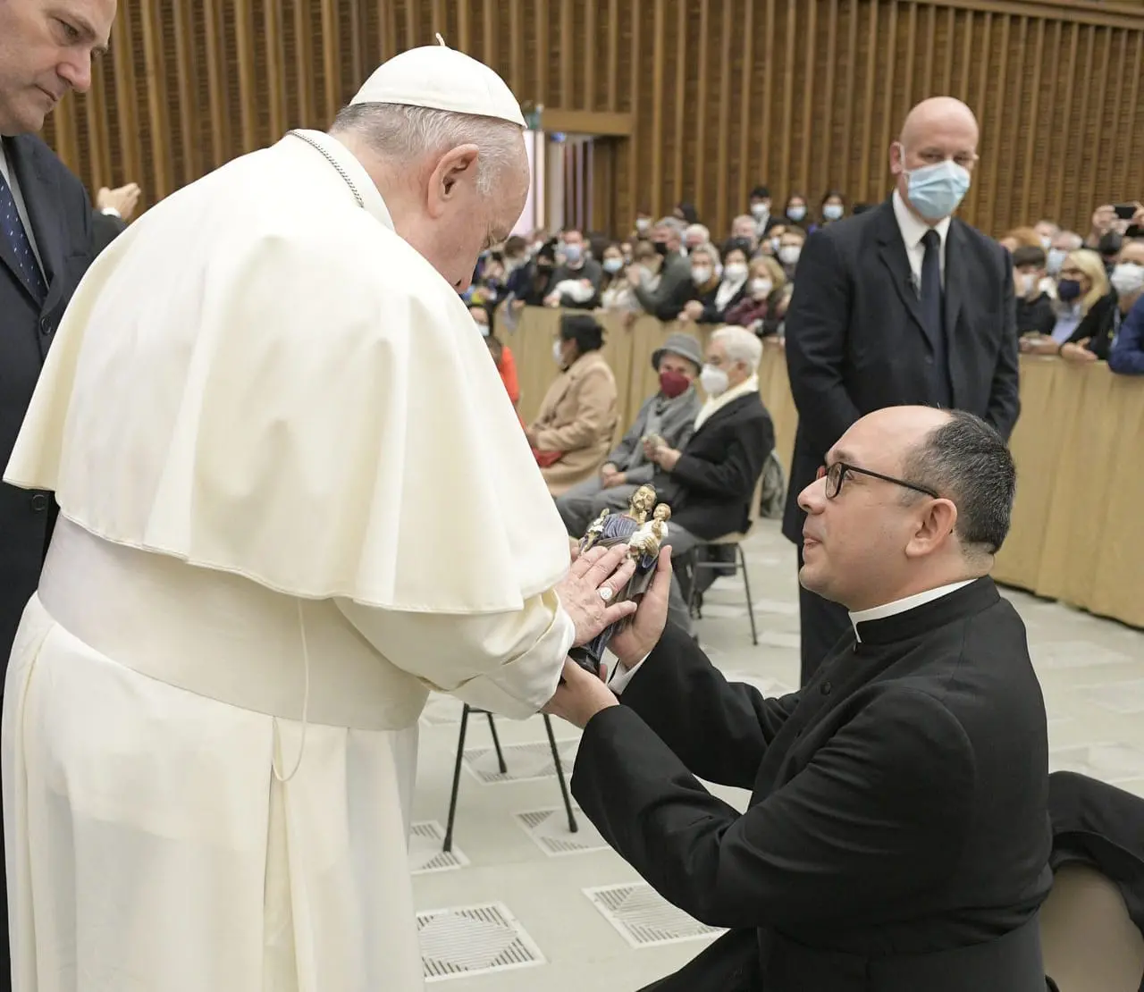 Padre cearense Rafhael Silva ajoelhado ao lado do papa Francisco
