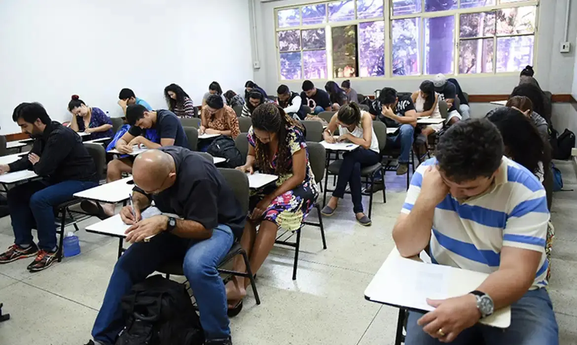 Na imagem vemos uma sala de aula composta por participantes da prova do Encceja