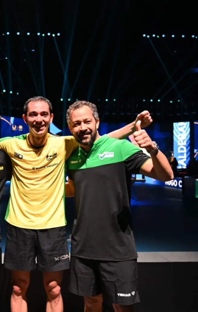 Foto de Hugo Calderano, campeão da Copa do Mundo de Tênis de Mesa, e Thiago Monteiro, cearense, treinador da Seleção Brasileira de Tênis de Mesa.