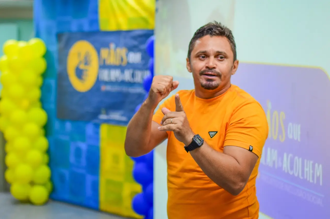 Homem utilizando a Língua Brasileira de Sinais (Libras) durante evento de lançamento do projeto 'Mãos que Falam e Acolhem' em Itaitinga (CE)
