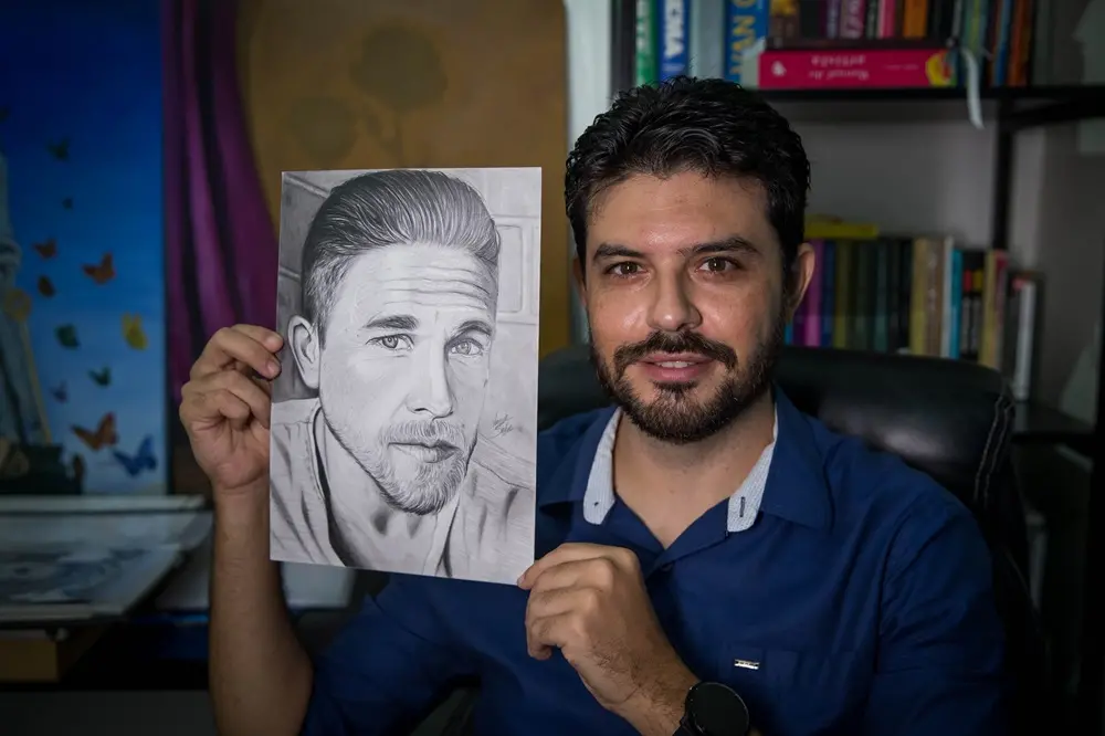 Na imagem, o artista Wagner Sales com um dos desenhos de autoria própria