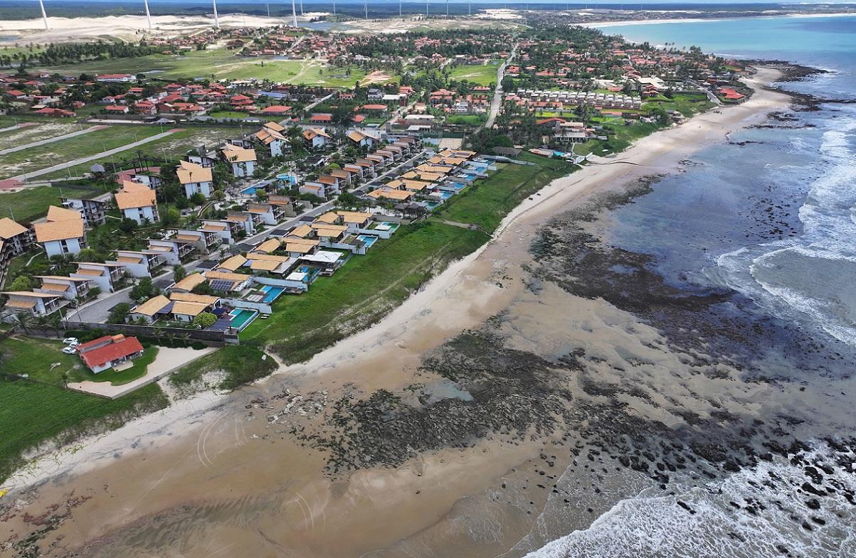 Foto de mar avançando em direção a casas na praia da Taíba