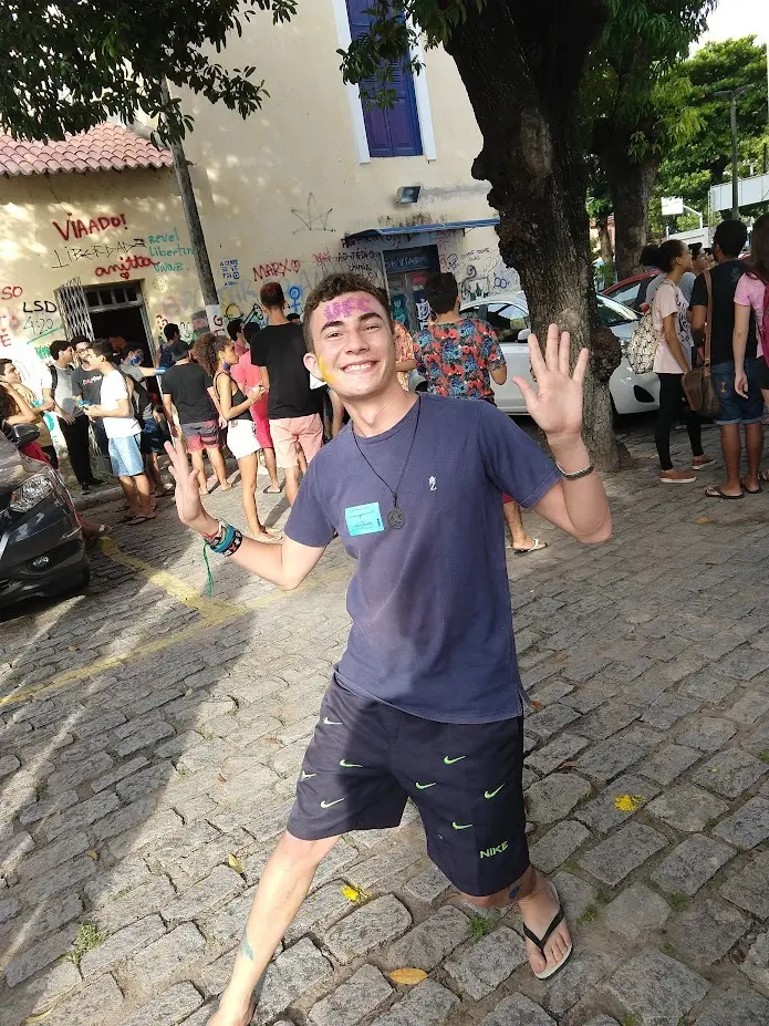 Jovem durante comemoração do vestibular. Na imagem, ele aparece com o nome UFC pintado na testa, enquanto sorri