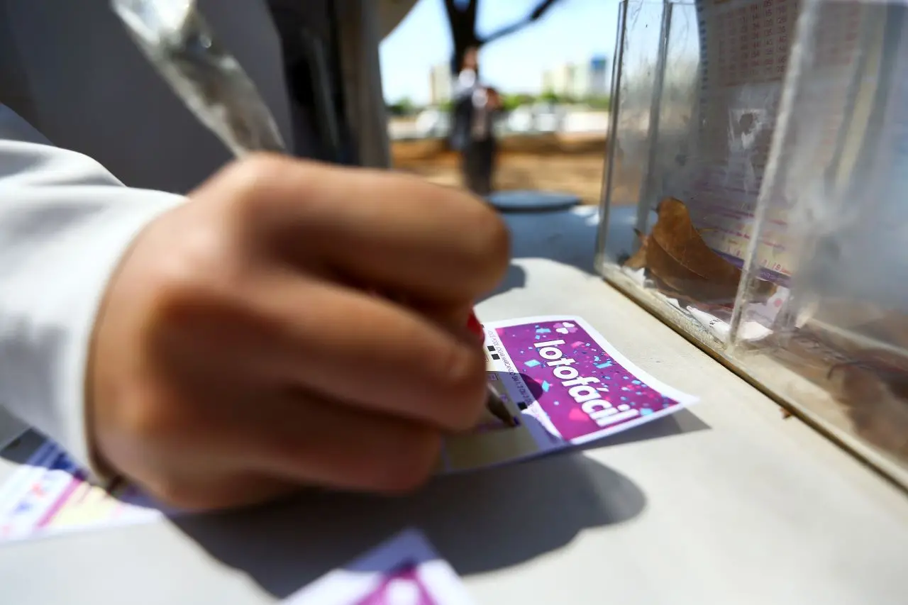 pessoa preenchendo cartela da lotofácil