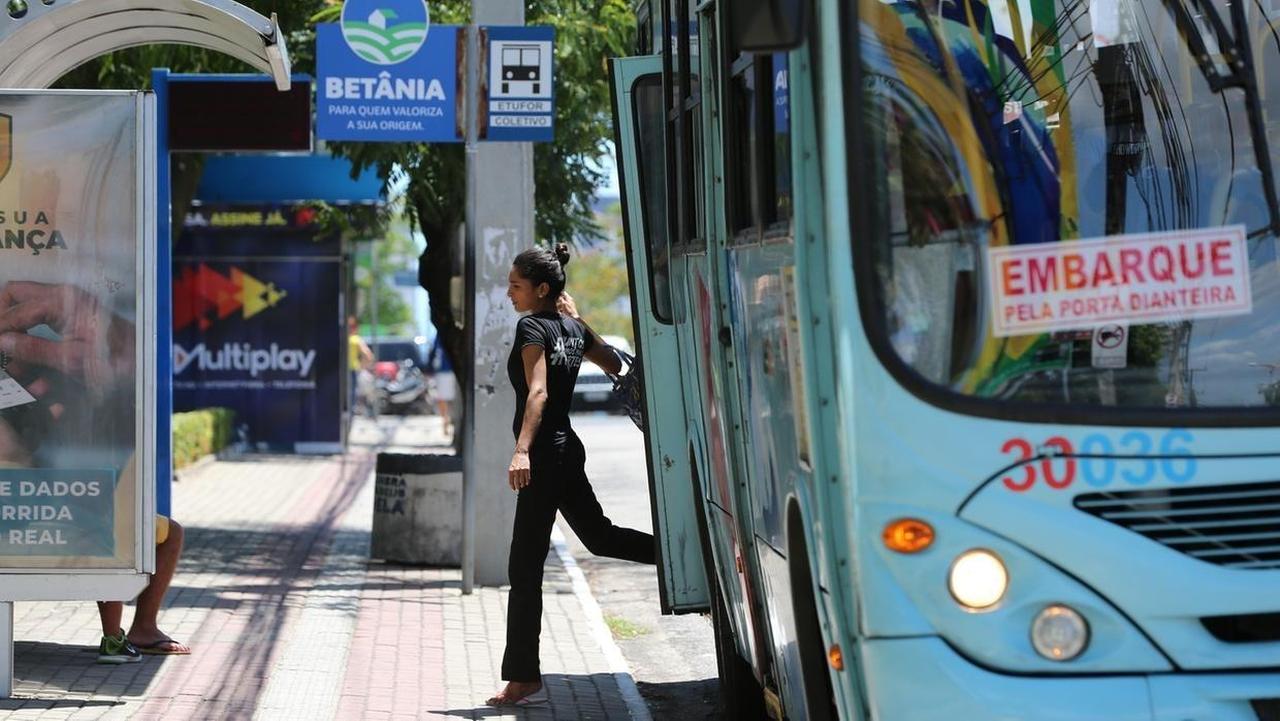 Imagem mostra passageira desembarcando de ônibus público em Fortaleza, ilustrando mudança de itinerário em linhas após chacina na Barra do Ceará. (Imagem ilustrativa)