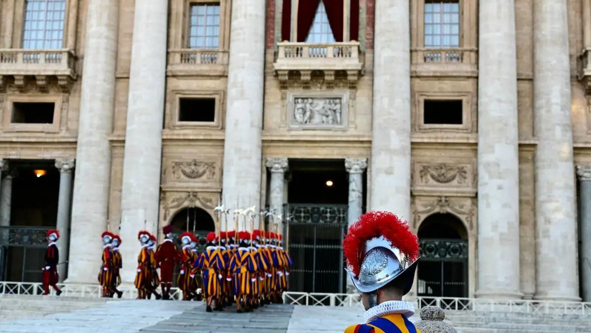 Foto do Vaticano com soldados em uniformes listrados em azul, vermelho e amarelo. Imagem está sendo usada na matéria sobre o motivo de nenhum papa escolher o nome do apóstolo São Pedro