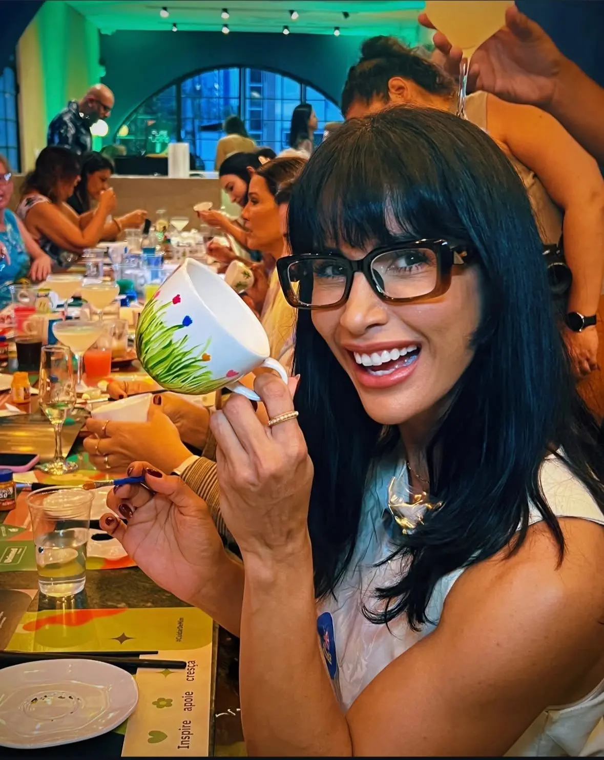 Mulher mostra caneca pintada em programação com o foco no Dia das Mães, em Fortaleza