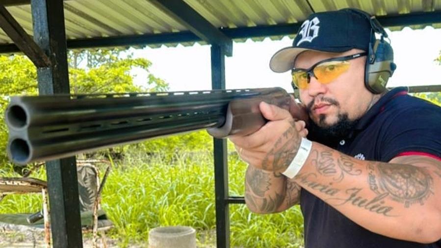 Ex-lutador Chiquerim galpão de tiro com escopeta em mãos mirando em alvo