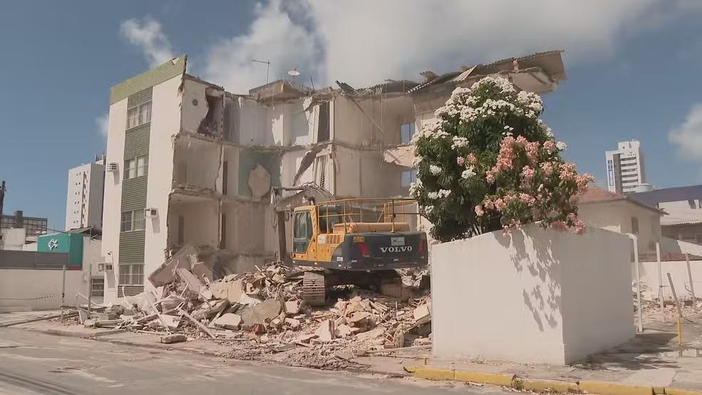 Imagem mostra o prédio parcialmente desabadom, com tijolos jogados sobre o chão e um guindaste em meio a ruìnas