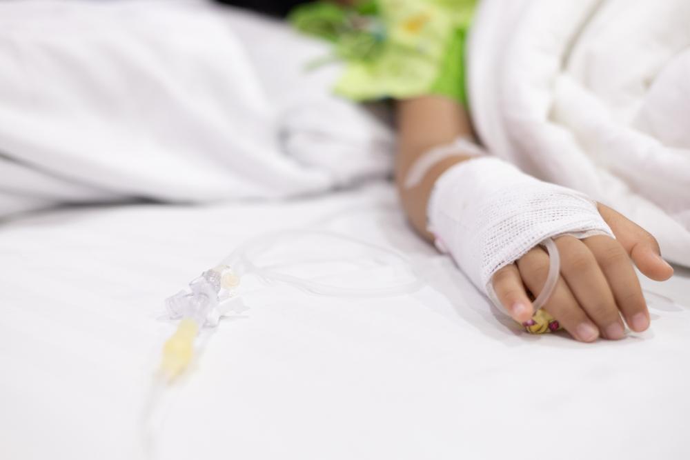 foto de criança em maca de hospital com acesso no braço