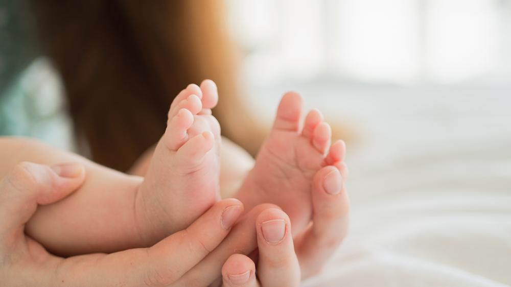 foto de mãe segurando pé de bebê