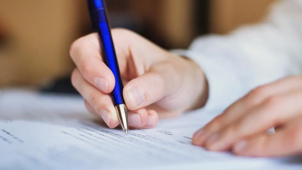 foto de candidato preenchendo prova com uma caneta azul