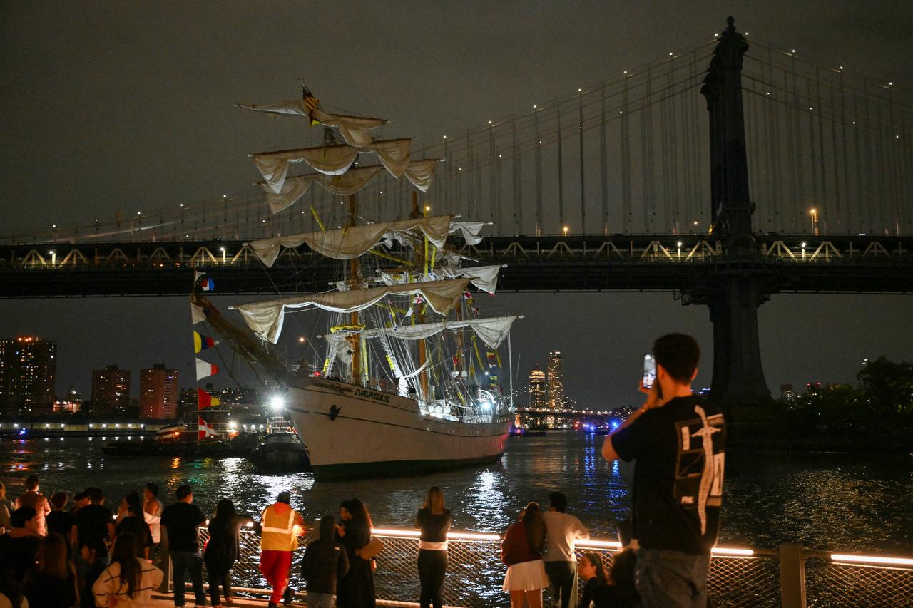 pessoas assistindo resgate de feridos em acidente de barco mexicano na ponte de NY
