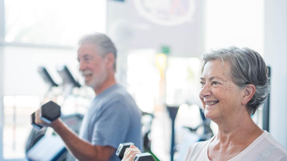 foto de dois idosos praticando musculação em uma academia