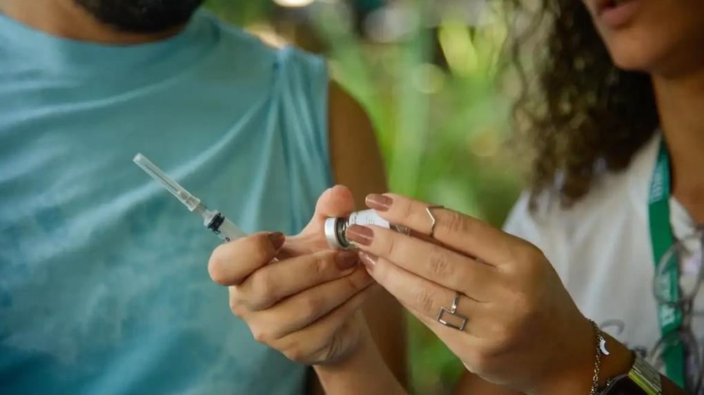 Mulher prepara vacina contra a gripe para aplicar em adulto, para matéria sobre Governo do Ceará ampliar vacinação