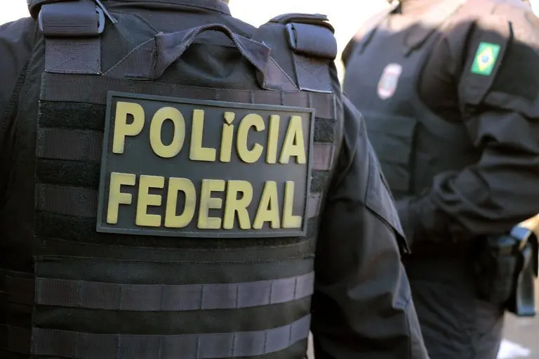 Imagem de agentes da Polícia Federal em ação, destacando os uniformes com o emblema da instituição, símbolo da segurança no Brasil.