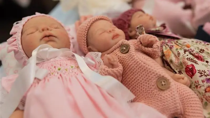 imagem contendo três bonecos hiper-realistas que simulam bebês humanos