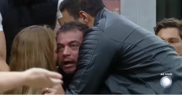 Imagem do participante Dhomini, do reality Power Couple, se exaltando durante dinâmica de quarta-feira (21); ele aparece na imagem sendo contido por outros participantes