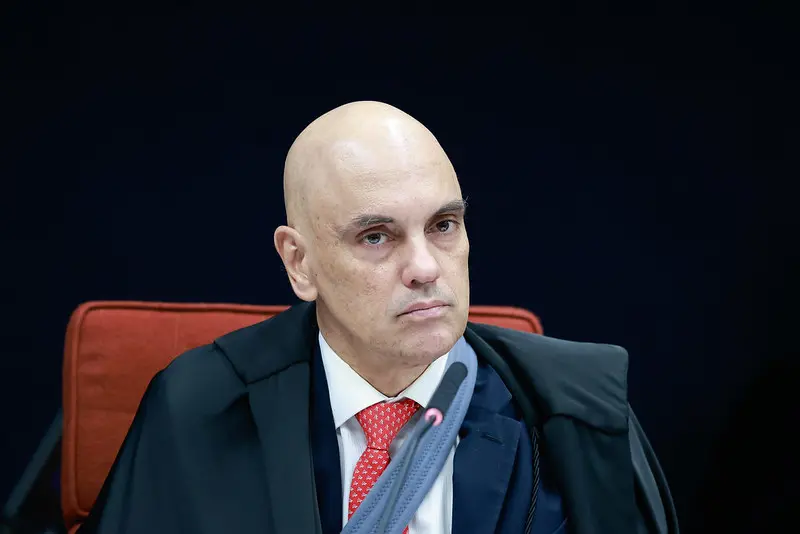 Ministro Alexandre de Moraes é um homem branco e careca e está de terno preto, camisa social branca e gravata vermelha. Para matéria sobre STF aceitar pedido da PGR e abrir inquérito contra Eduardo Bolsonaro