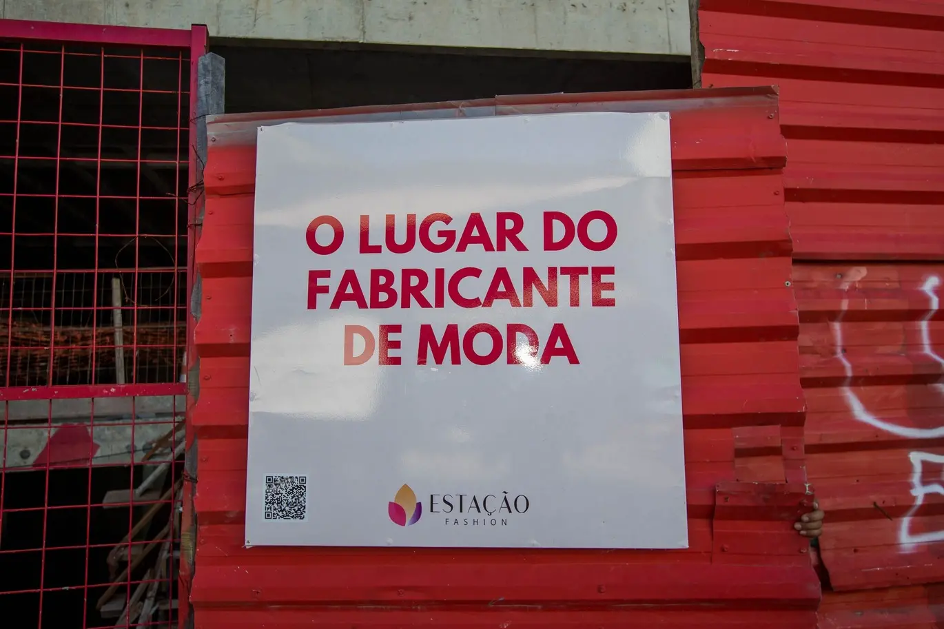 Foto que contém uma das fachadas do Estação Fashion, no Centro de Fortaleza. Há uma frase na tela com os dizeres em vermelho 