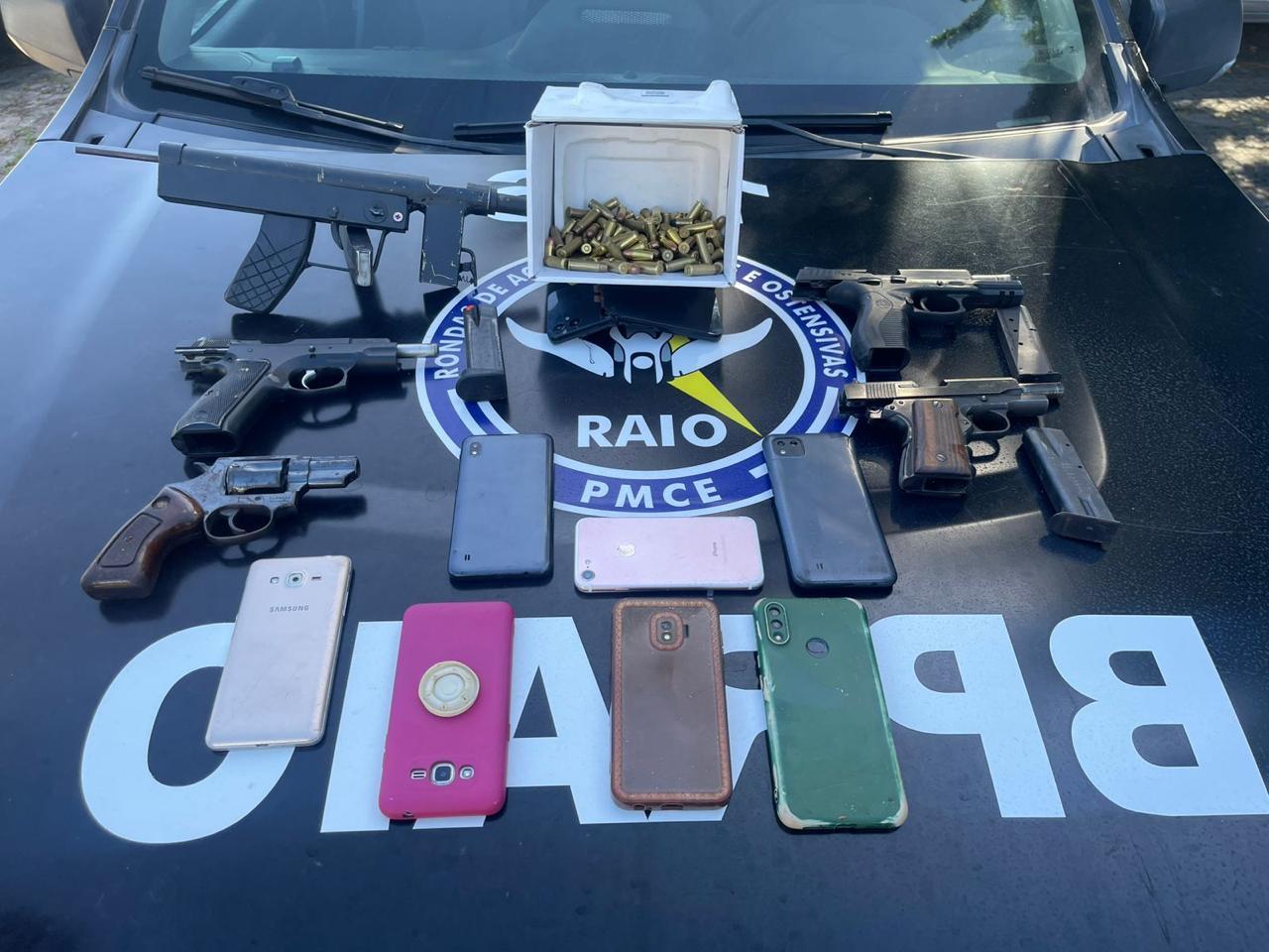 Foto mostra armas de fogo, munições e aparelhos celulares apreendidos com suspeitos de duplo homicídio em Fortaleza. Material está em cima de viatura da Polícia Militar