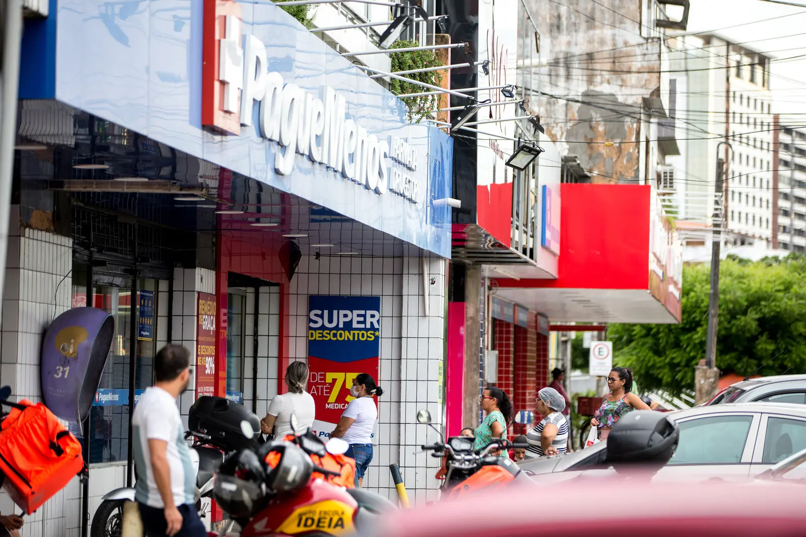 Imagem mostra movimentação de clientes em frente à fachada da farmácia Pague Menos, em Fortaleza
