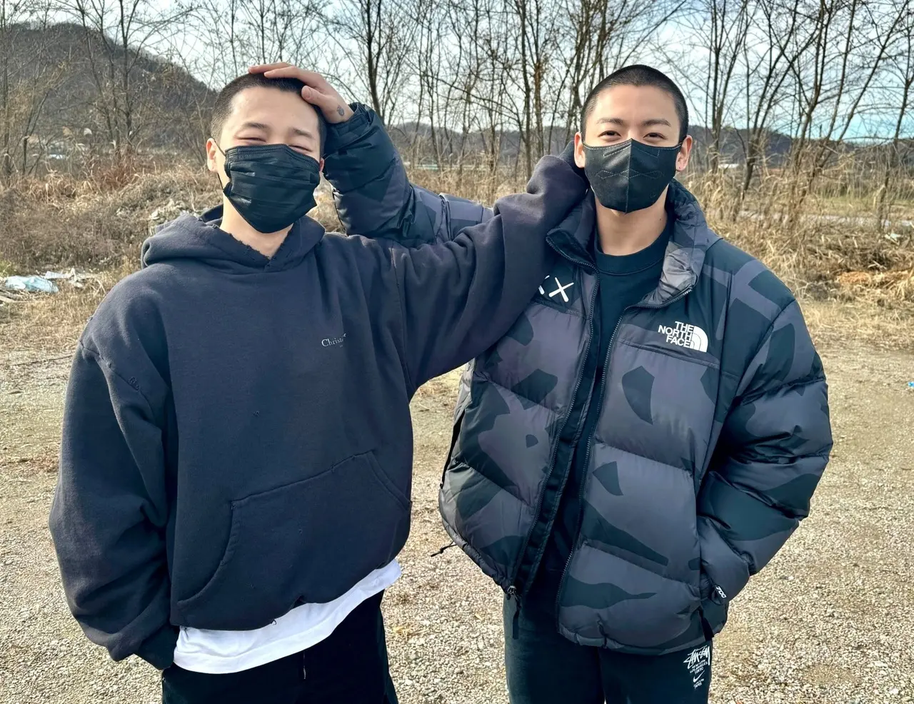Imagem mostra Jimin e Jung Kook, membros do grupo de k-pop do BTS, com cabeça raspada, ilustrando ao vivo da dispensa militar do Exército